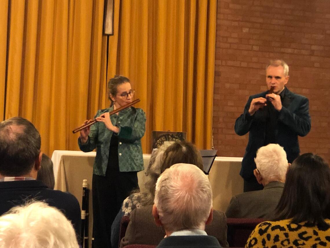 Audience listen to James on a tiny recorder and Rachel on baroque flute