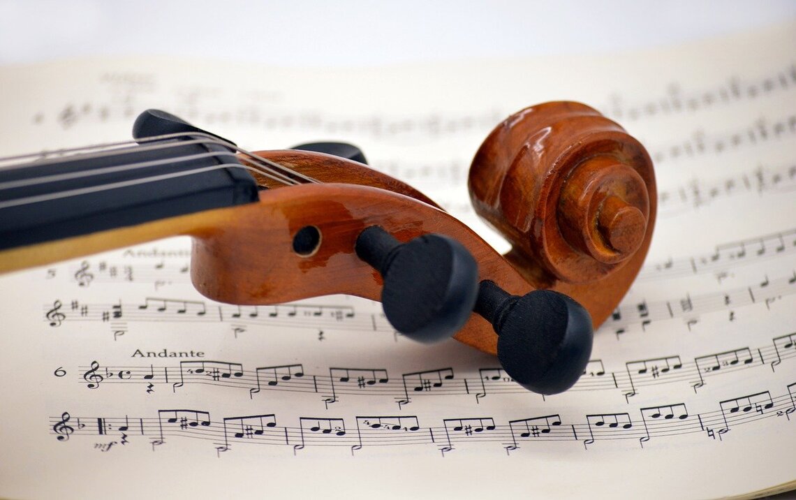 Close up of violin lying on a page of sheet music by neelam275 Pixabay