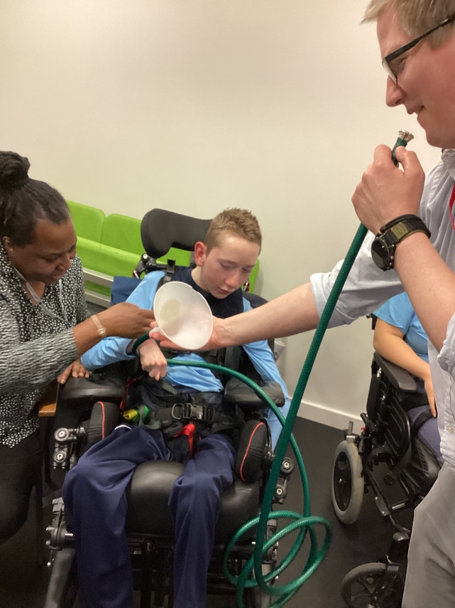 Martin plays the hosepipe for everyone to feel the vibrations inside it